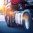 Roter Sattelzug f&auml;hrt bei Sonnenuntergang auf der Autobahn